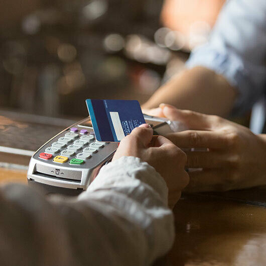 a woman uses a credit card in a store