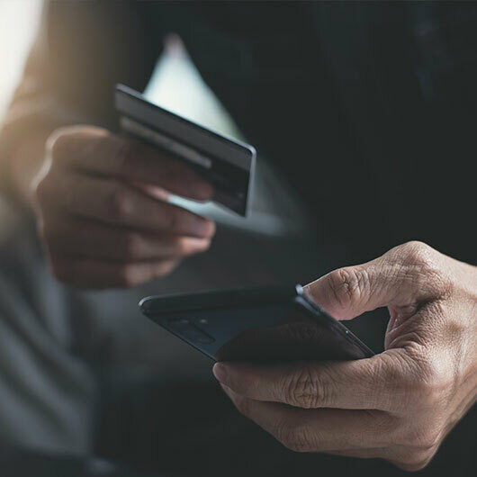 A man types his credit card info into his cellphone